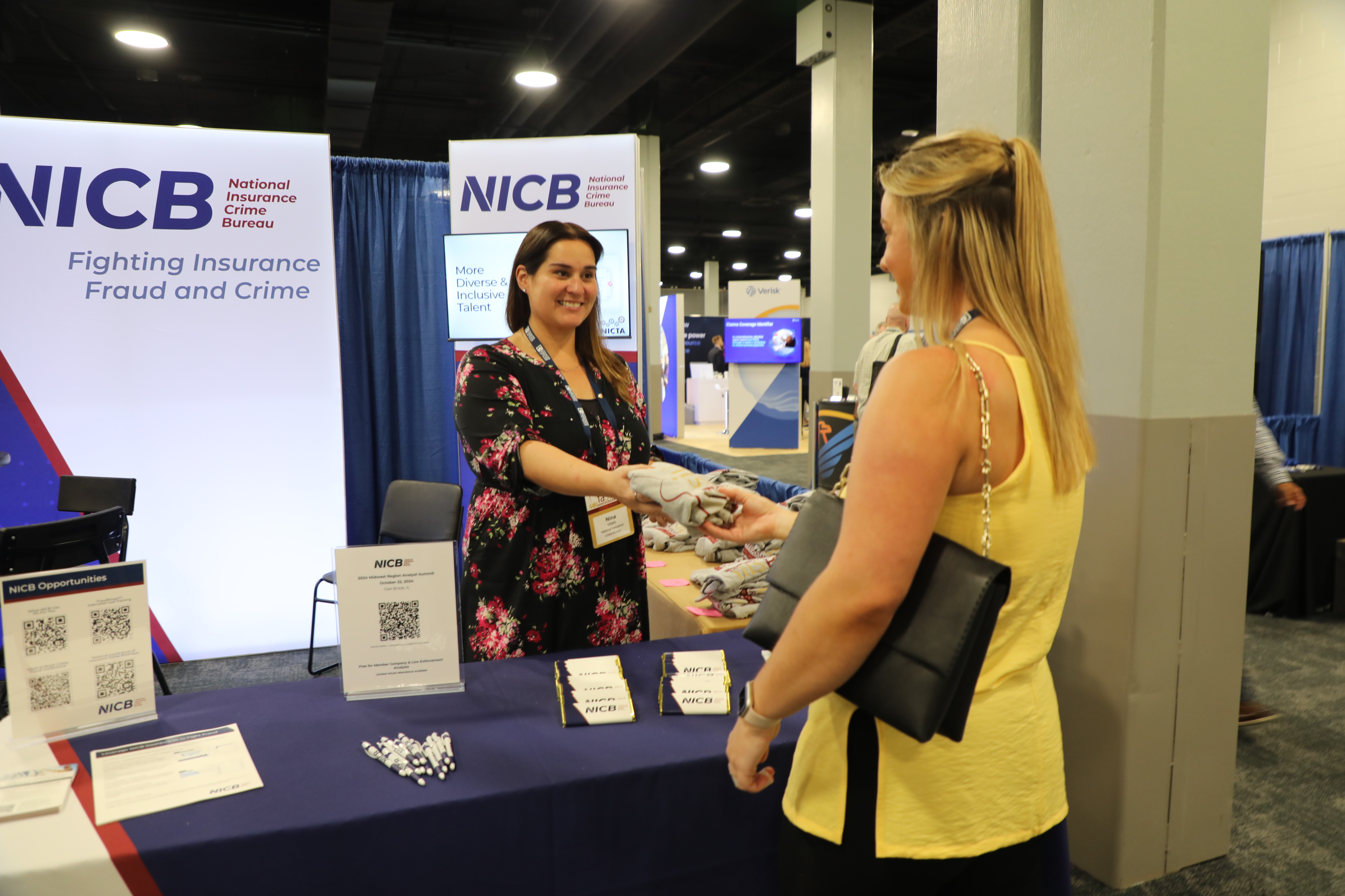 Woman handing woman item of merchandise from booth