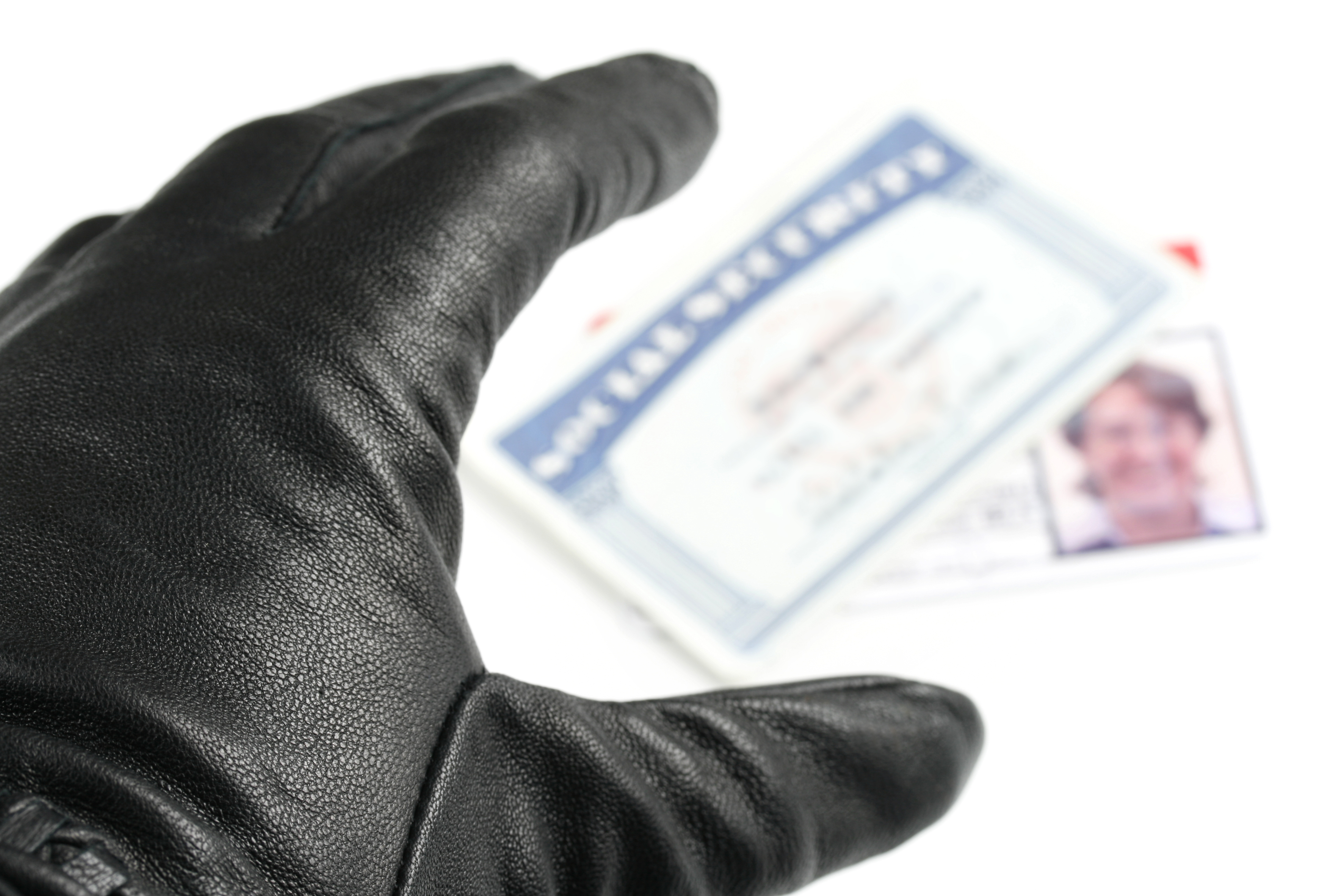 A gloved hand stealing a social security card