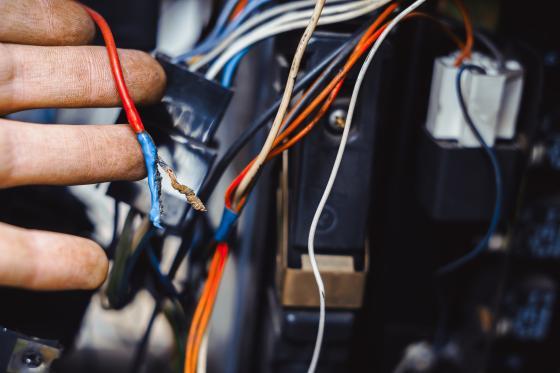 Fingers on car wires in dashboard
