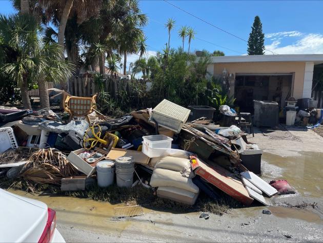 Pile of debris on street following Hurricane Helene flood damage